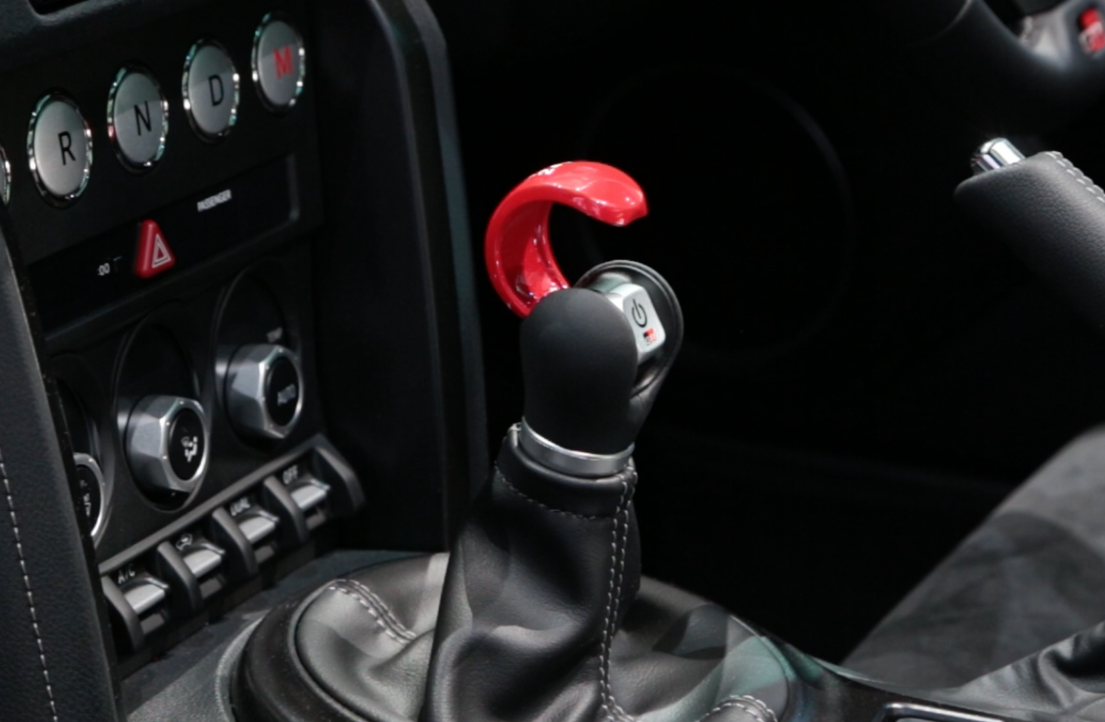 Once a button under the red flap is pushed, the manual mode is engaged, letting the driver shift in a six-speed 'H' pattern